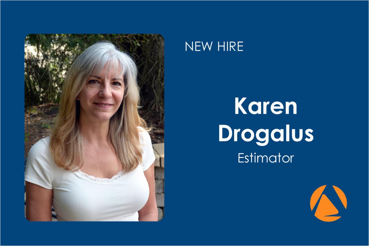 A portrait of a woman with light gray hair and a white top on the left side, set against a natural outdoor background. The right side of the image contains a blue background with white text reading 'New Hire, Karen Drogalus, Estimator' and a logo in orange at the bottom.