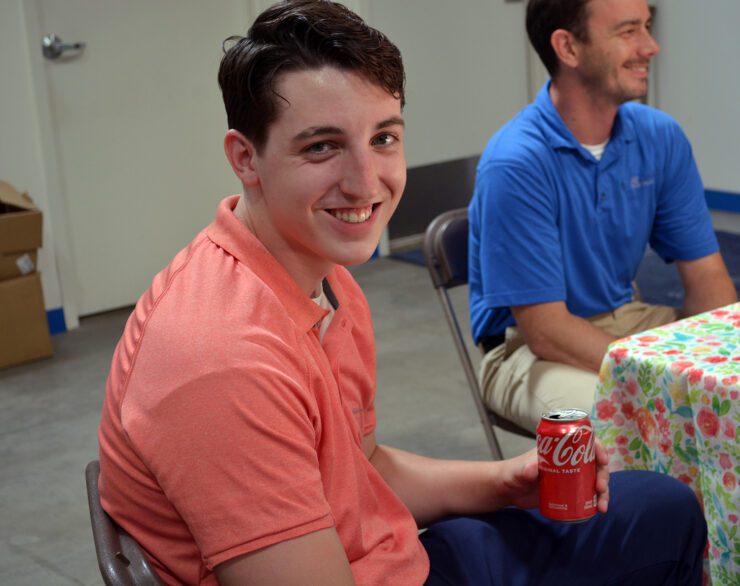 Young Man Holding Coca Cola Can Smiling | Air Control Products Ryan Tomblin attend our June Firedrill