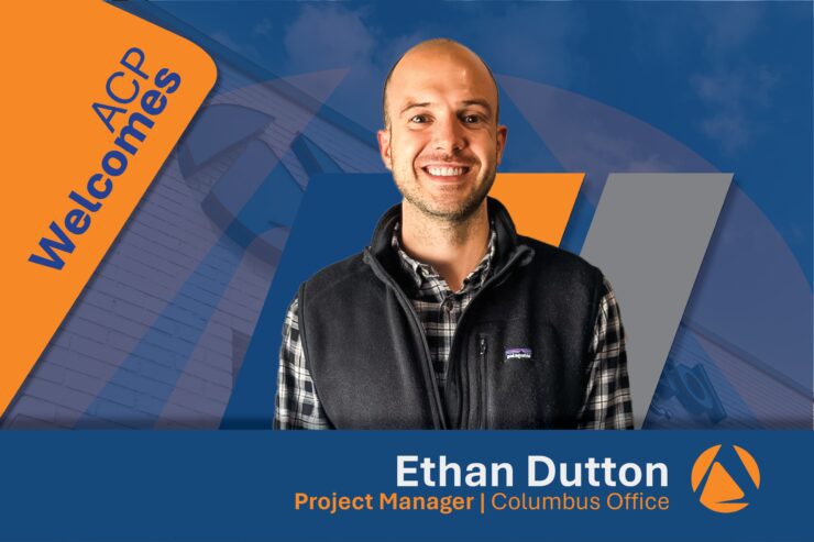 A welcoming graphic for a new project manager at the Columbus office. The man is smiling, dressed casually with a black vest over a plaid shirt. Text on the image says 'ACP Welcomes' and identifies him as Ethan Dutton, Project Manager at the Columbus Office, with a background featuring an abstract design and building.